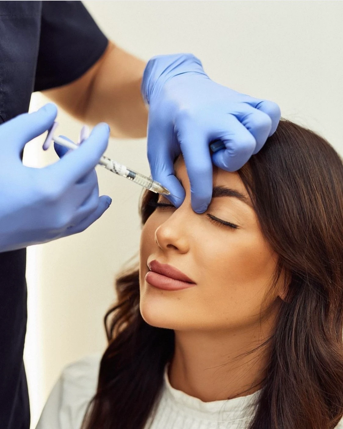 Ezen a képen egy barna hajú nő látható, amint épp botox kezelést kap.